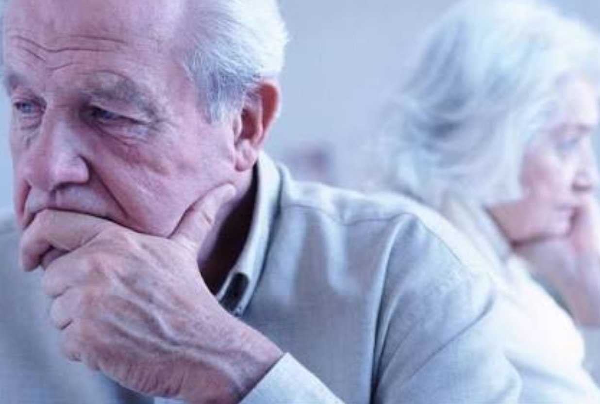 an older man and woman sitting at a table