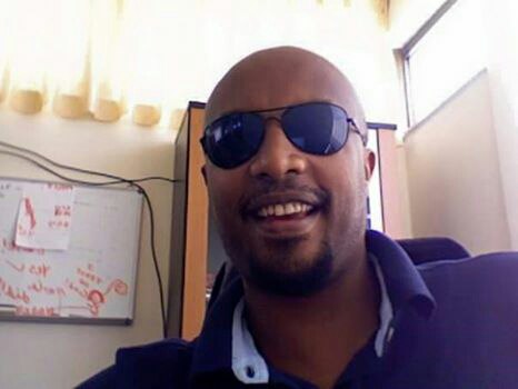 a man in a blue shirt and sunglasses