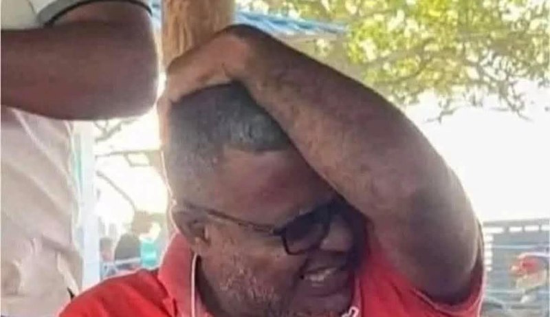 a man in a red shirt is holding his head